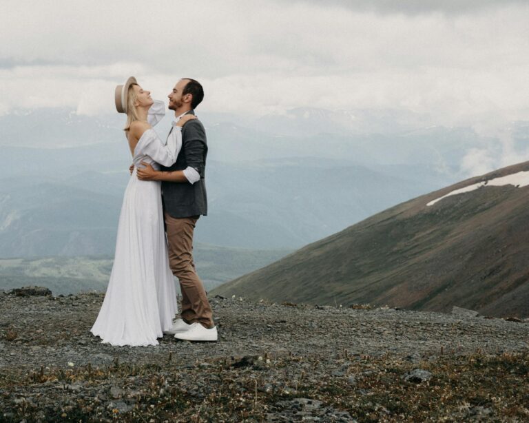 Newlywed couple embracing against ridges on wedding day