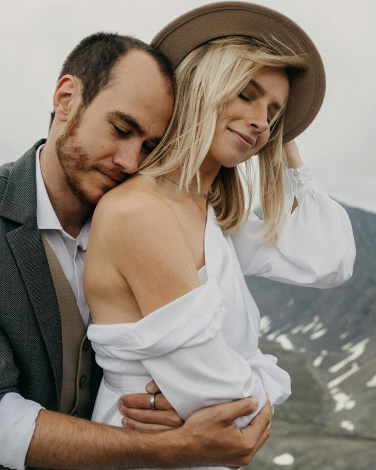 Newlywed couple with closed eyes embracing on highland